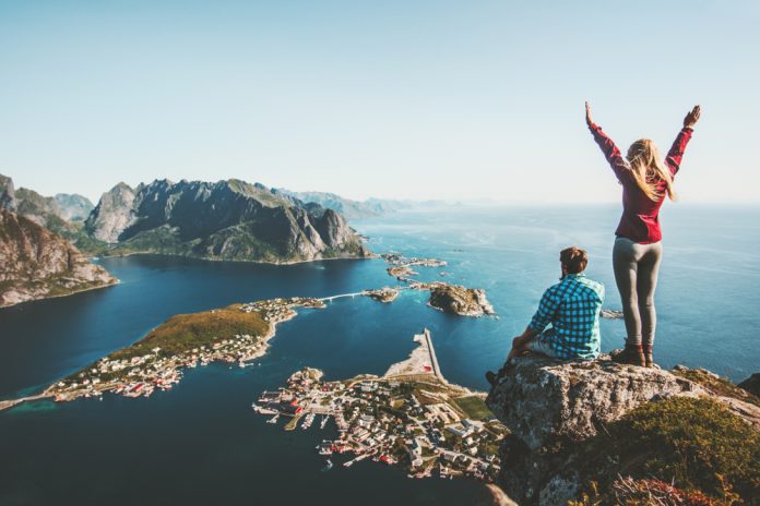 Couple,Family,Traveling,Together,On,Cliff,Edge,In,Norway,Man